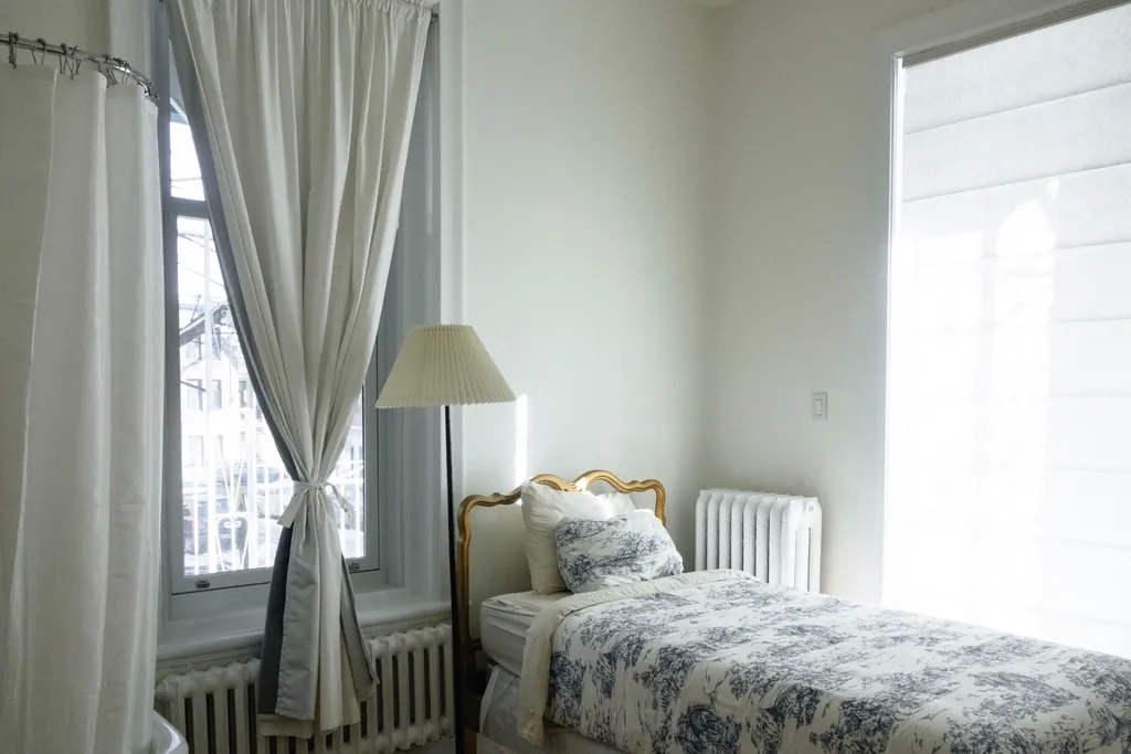 Tailored curtains tied back in a classic guest bedroom